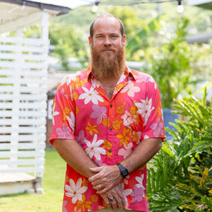man wearing pink aloha button up shirt with retro flower pattern