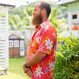 man wearing pink aloha button up shirt with retro flower pattern