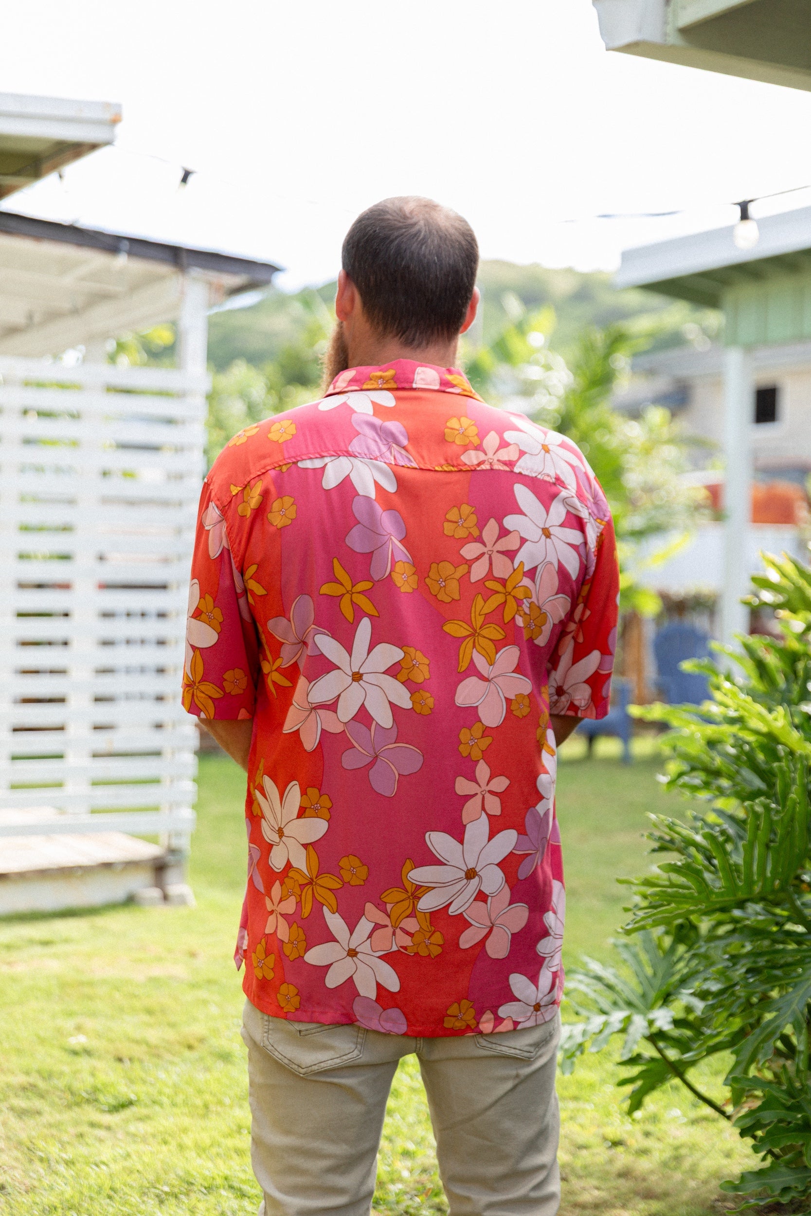 man wearing pink aloha button up shirt with retro flower pattern