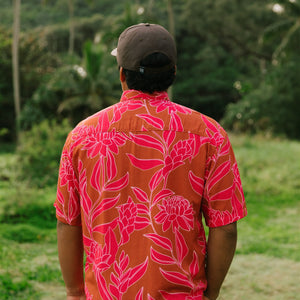 Man in brown button up shirt with large pink floral print