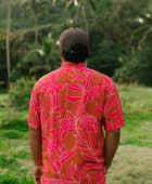 Man in brown button up shirt with large pink floral print