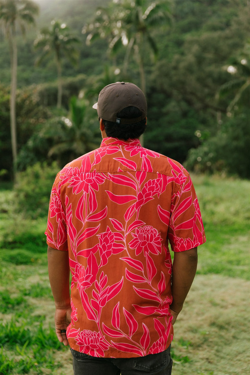 Man in brown button up shirt with large pink floral print