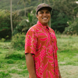 Man in brown button up shirt with large pink floral print