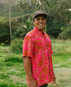 Man in brown button up shirt with large pink floral print