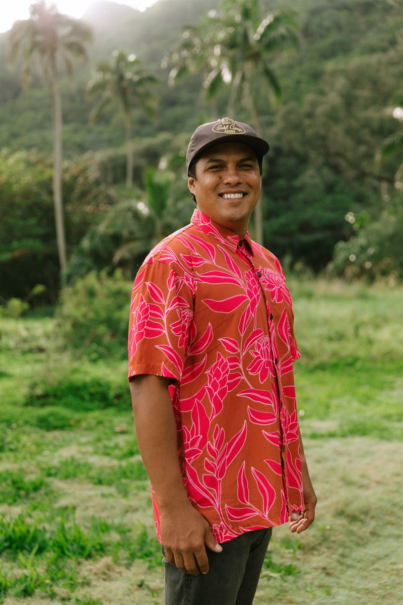 Man in brown button up shirt with large pink floral print