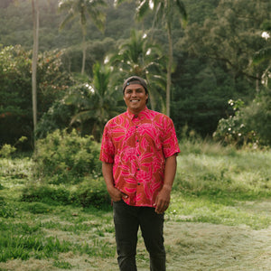 Man in brown button up shirt with large pink floral print