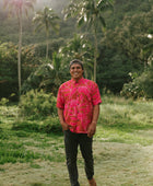 Man in brown button up shirt with large pink floral print