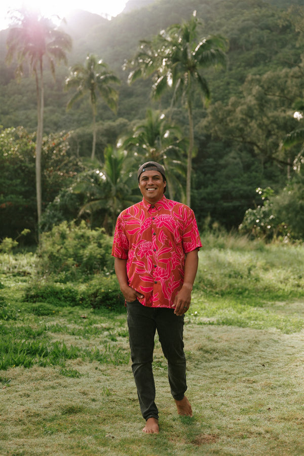 Man in brown button up shirt with large pink floral print