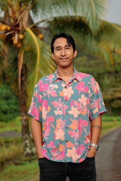 man wearing a teal aloha button up shirt with pink and orange floral pattern