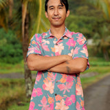 man wearing a teal aloha button up shirt with pink and orange floral pattern