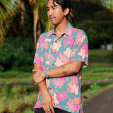 man wearing a teal aloha button up shirt with pink and orange floral pattern