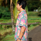 man wearing a teal aloha button up shirt with pink and orange floral pattern