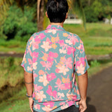 man wearing a teal aloha button up shirt with pink and orange floral pattern