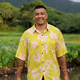man wearing bright yellow green aloha button up shirt with orchid print 