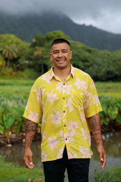 man wearing bright yellow green aloha button up shirt with orchid print 