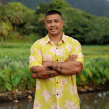 man wearing bright yellow green aloha button up shirt with orchid print 