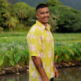 man wearing bright yellow green aloha button up shirt with orchid print 