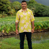 man wearing bright yellow green aloha button up shirt with orchid print 