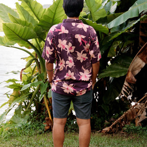 man wearing dark purple aloha shirt with orchid print