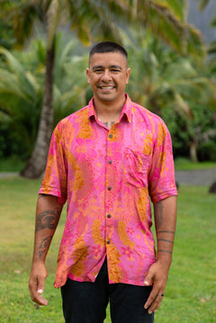 man wearing pink aloha button up shirt with lei strands