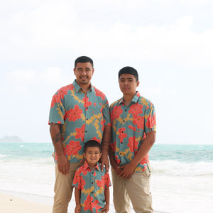man wearing green button up shirt with orange and yellow lei pua print