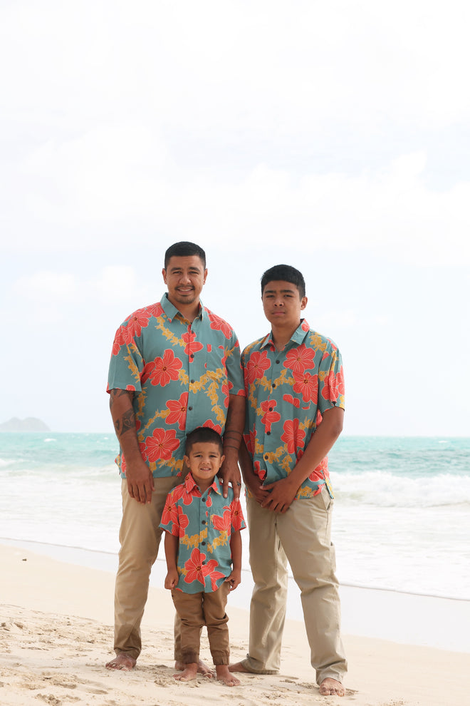 man wearing green button up shirt with orange and yellow lei pua print