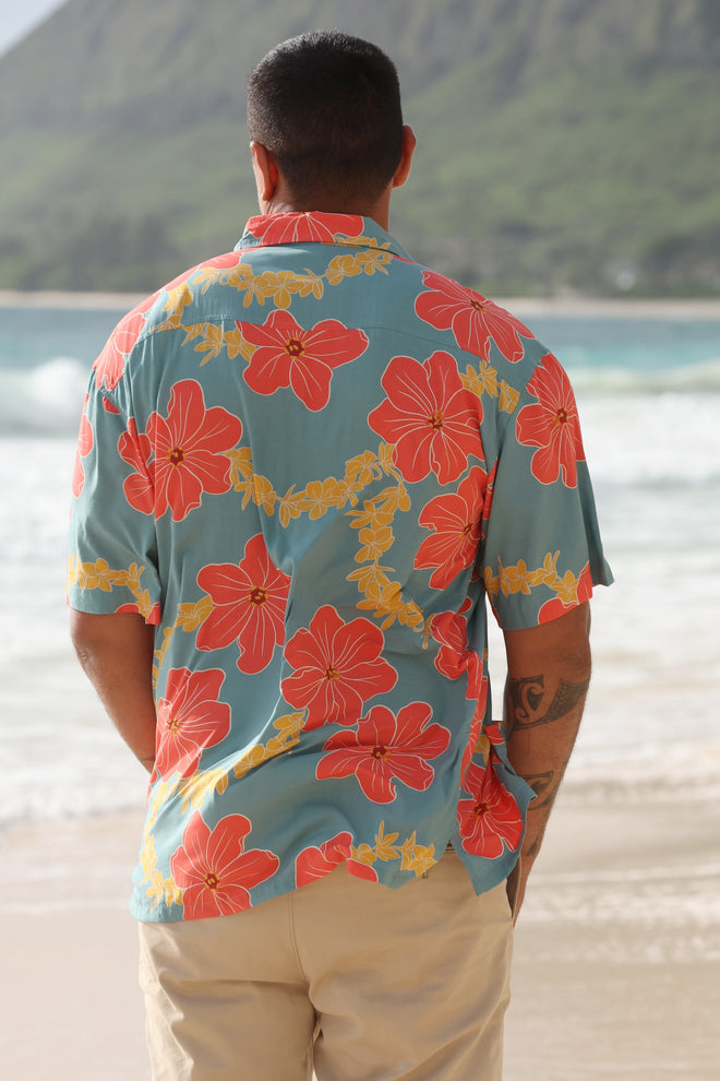 man wearing green button up shirt with orange and yellow lei pua print