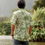 man wearing green aloha button up shirt with Native Hawaiian plant pattern