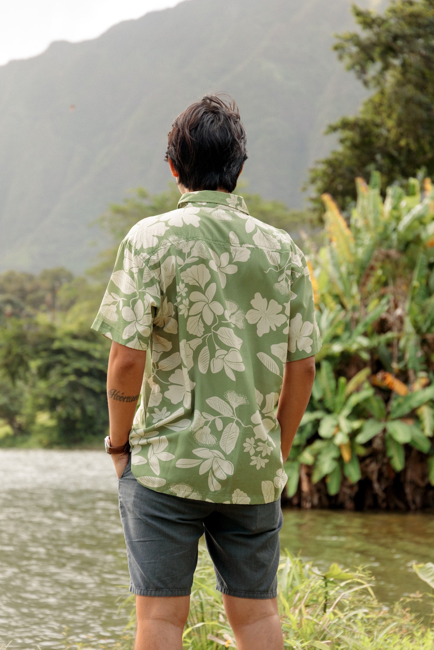 man wearing green aloha button up shirt with Native Hawaiian plant pattern