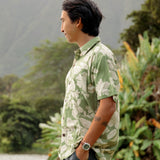 man wearing green aloha button up shirt with Native Hawaiian plant pattern