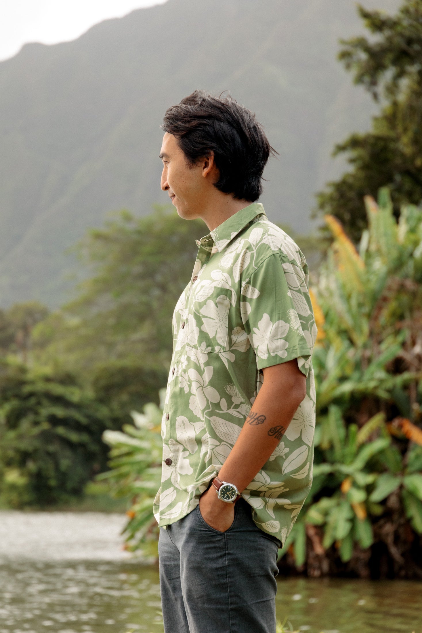 man wearing green aloha button up shirt with Native Hawaiian plant pattern