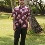 man wearing brown button up aloha shirt with protea print