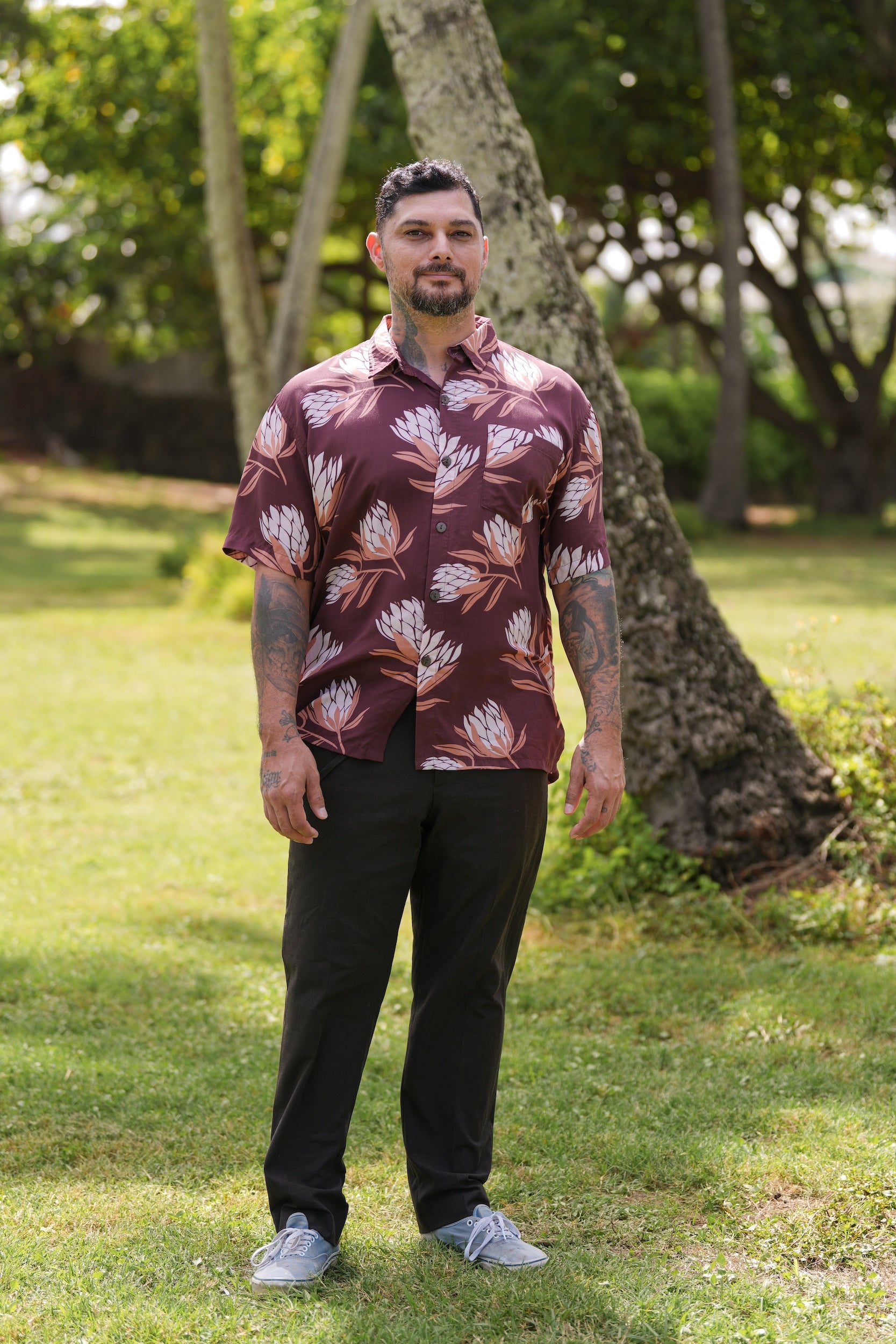man wearing brown button up aloha shirt with protea print