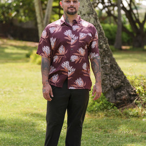 man wearing brown button up aloha shirt with protea print