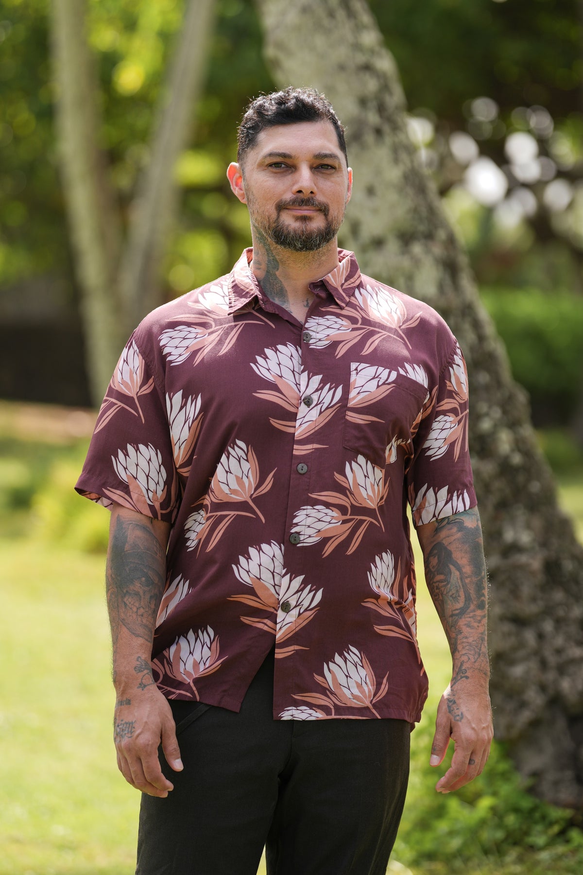 man wearing brown button up aloha shirt with protea print