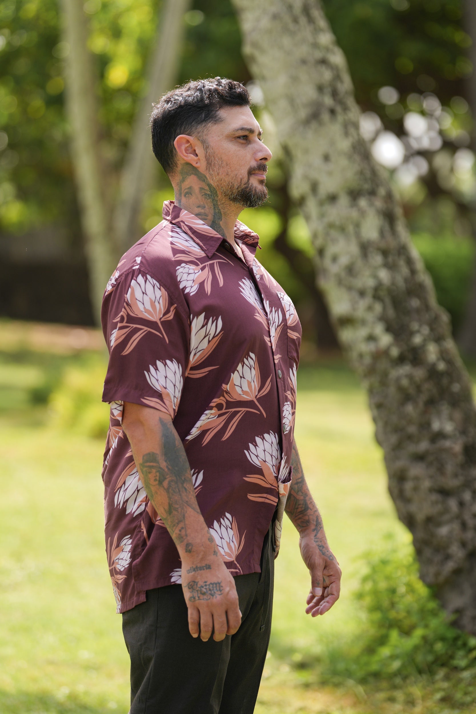 man wearing brown button up aloha shirt with protea print