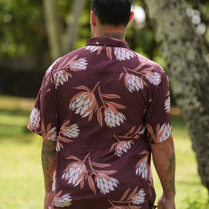 man wearing brown button up aloha shirt with protea print