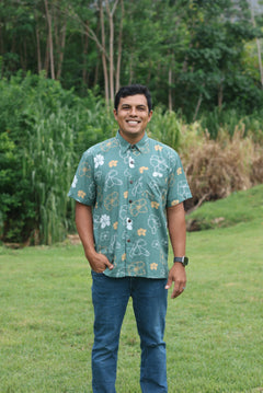 man wearing lush green aloha button-up shirt with pua kenikeni print