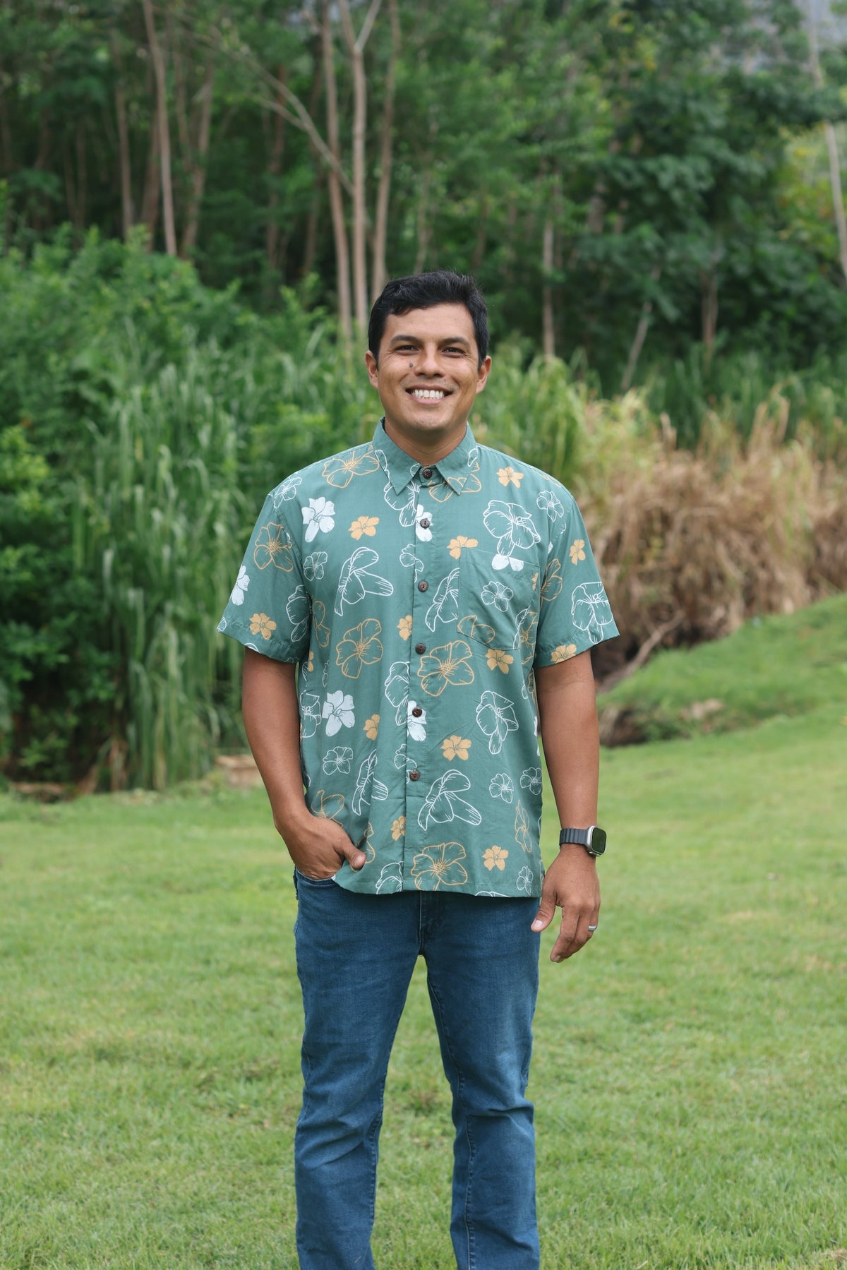 man wearing lush green aloha button-up shirt with pua kenikeni print