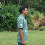 man wearing lush green aloha button-up shirt with pua kenikeni print