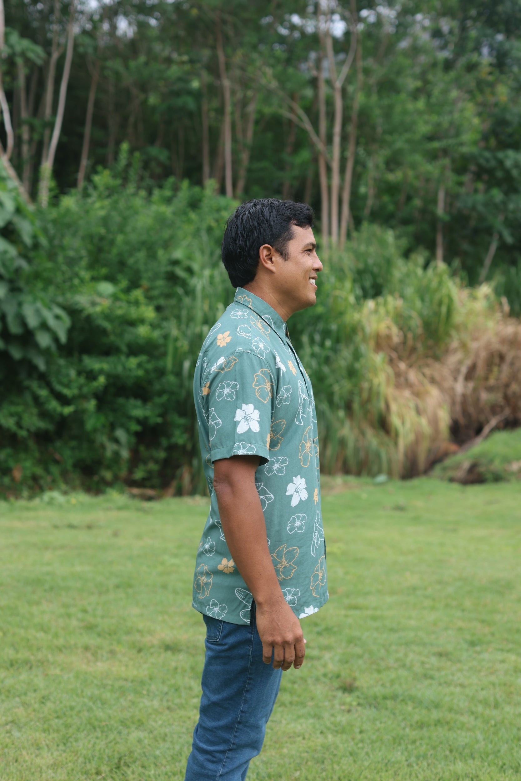 man wearing lush green aloha button-up shirt with pua kenikeni print