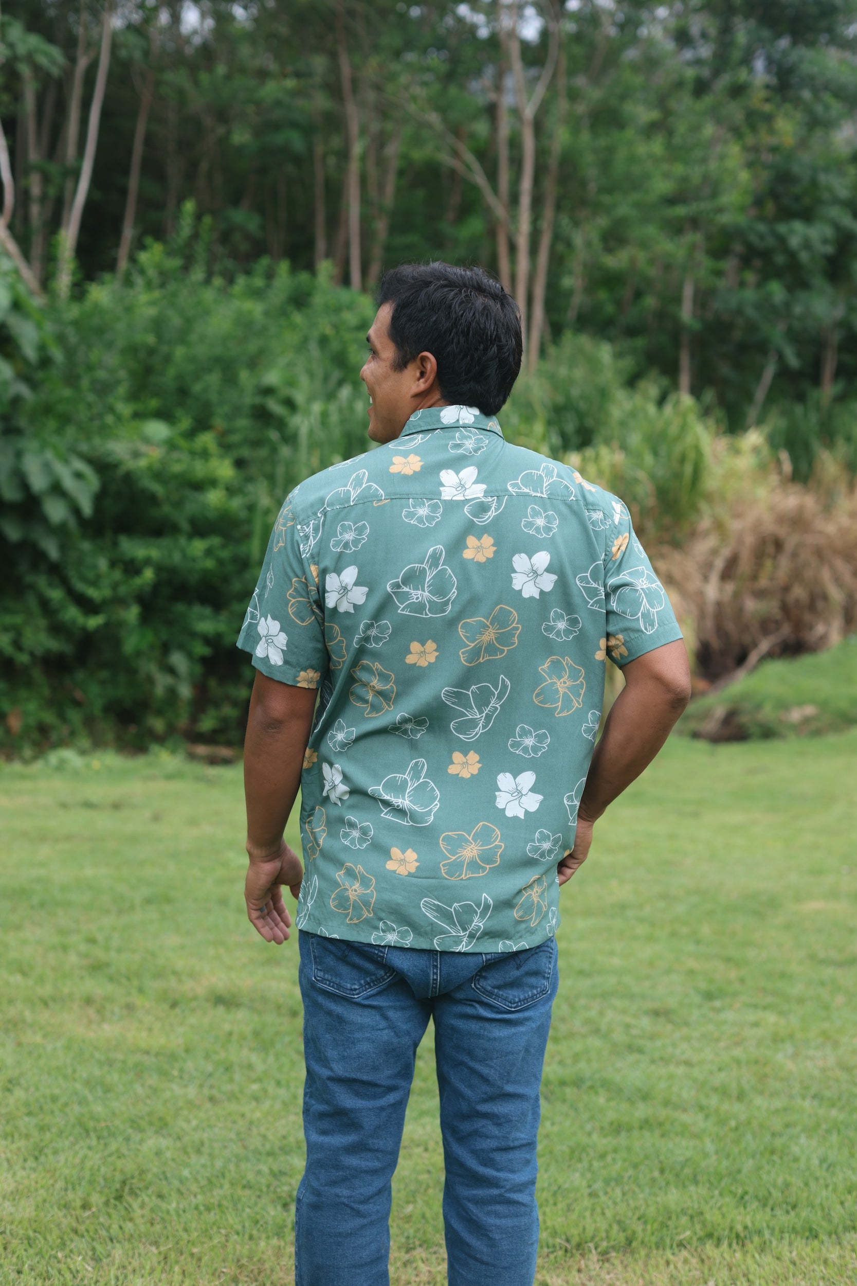 man wearing lush green aloha button-up shirt with pua kenikeni print