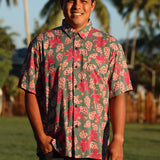 man wearing a teal aloha shirt with shell and pua print