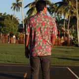man wearing a teal aloha shirt with shell and pua print