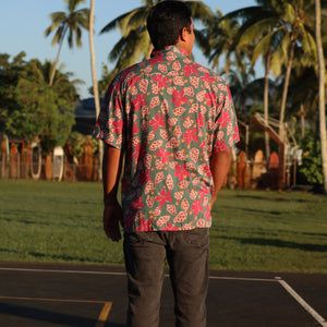 man wearing a teal aloha shirt with shell and pua print