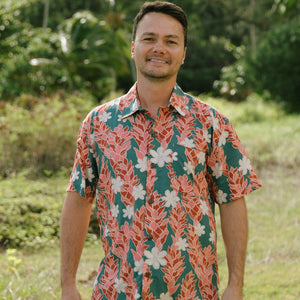 man wearing an aloha button up shirt with red ginger and tiare print