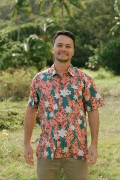 man wearing an aloha button up shirt with red ginger and tiare print