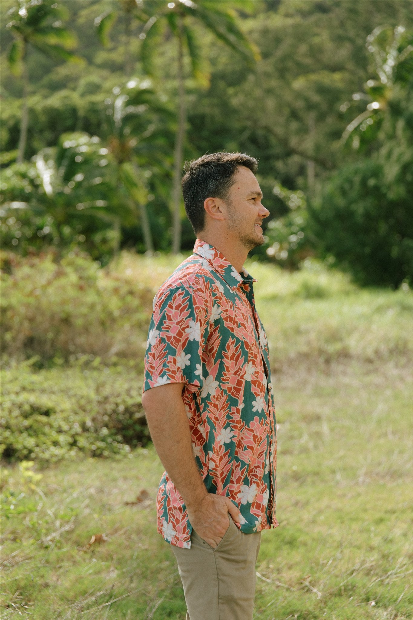 man wearing an aloha button up shirt with red ginger and tiare print