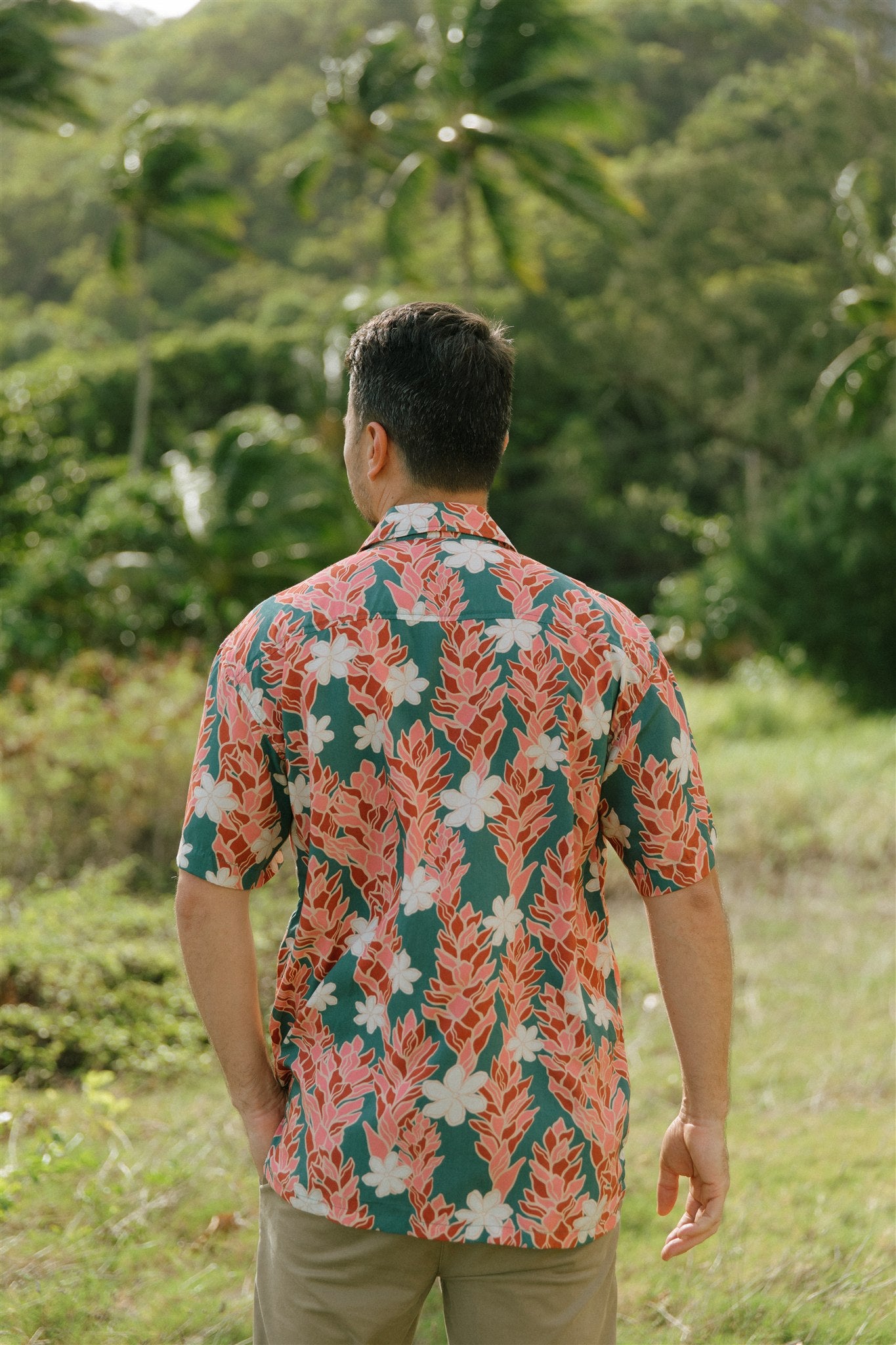 man wearing an aloha button up shirt with red ginger and tiare print