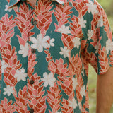 man wearing an aloha button up shirt with red ginger and tiare print